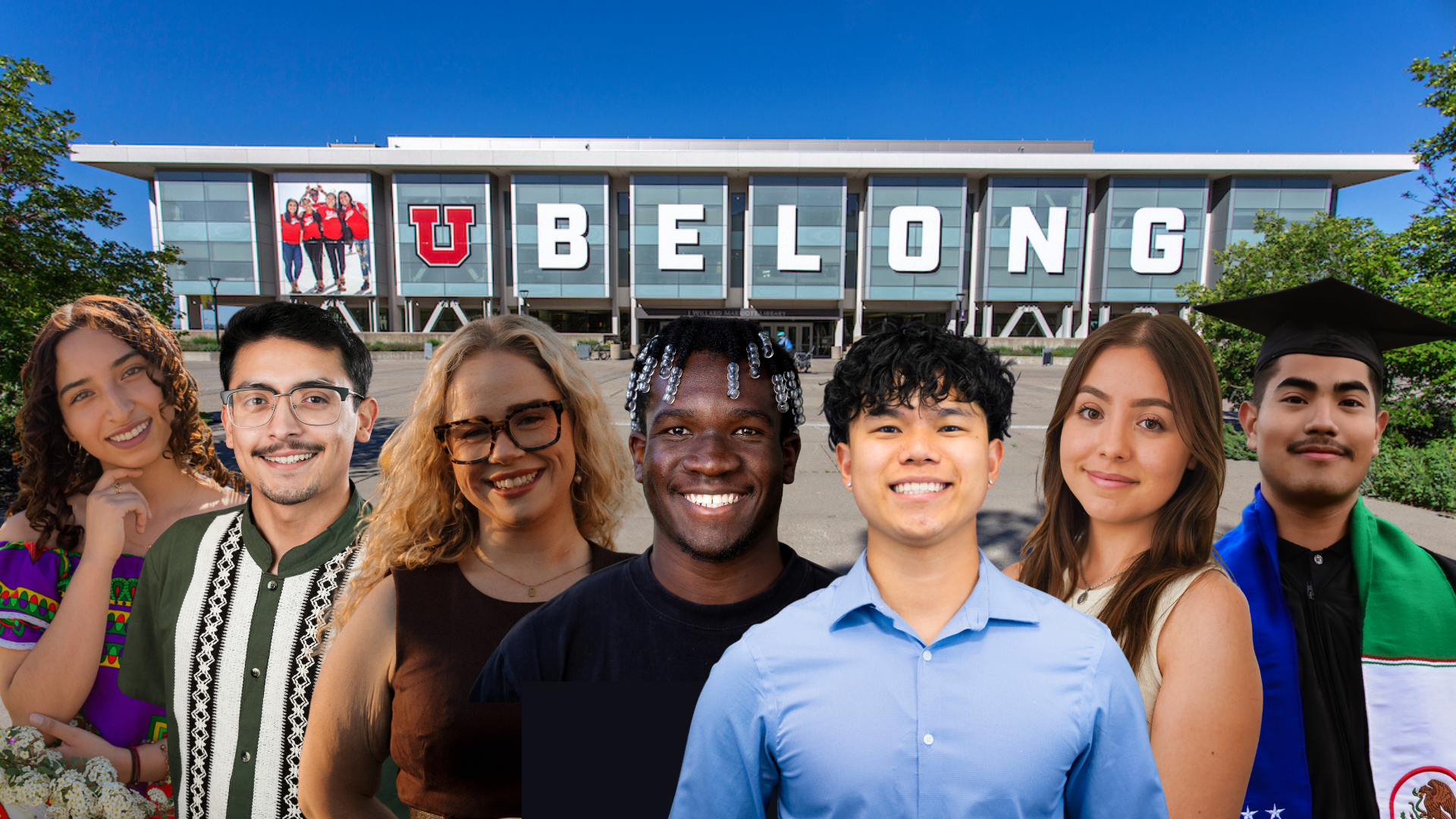 a diverse group of students smile and pose in front of the library. The library has the writing "U Belong" on it's windows. 