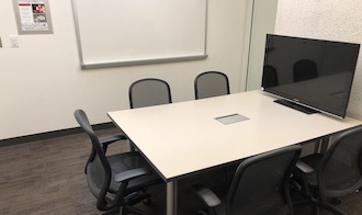 table, 2 chairs, whiteboard, and projector screen