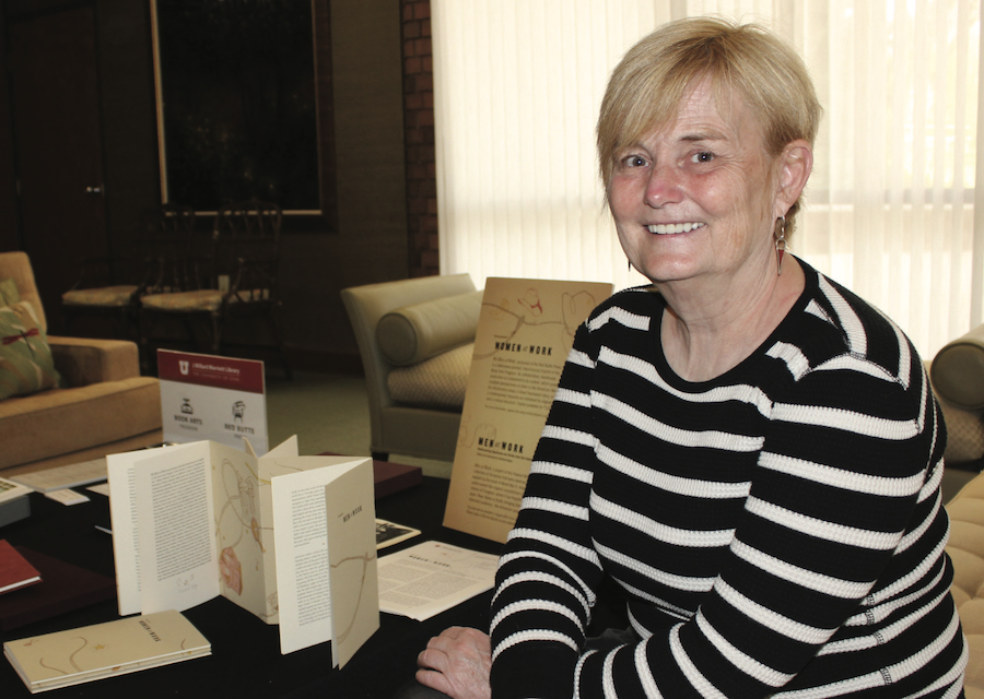 Becky Williams Thomas sitting next to Book Arts display