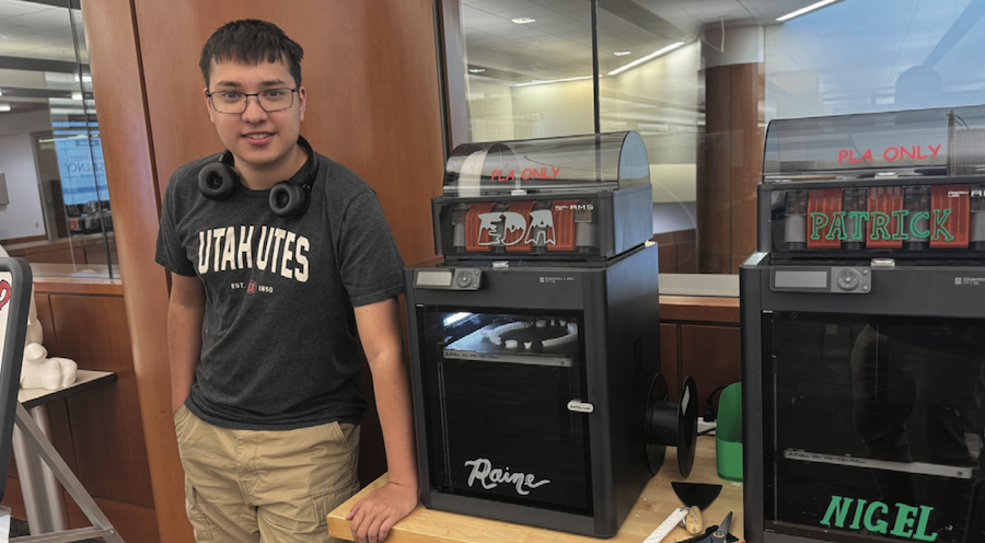 Ben Ramirez next to 3D printers in Protospace