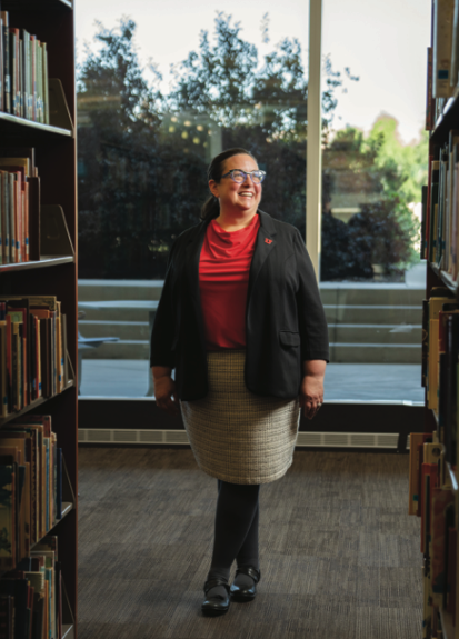Portrait of Dean Sarah Shreeves in the library between stacks of books