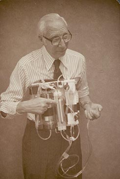 Sepia photograph of Willem Kolff demonstrating the wearable kidney created by the University of Utah biomedical division.