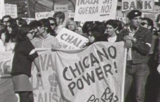 black and white historic photo of students holding signs that say Chicano Power